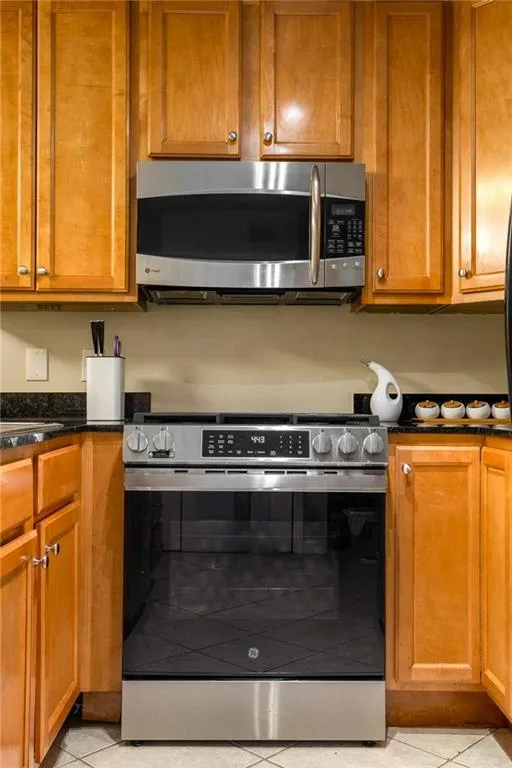 Kitchen featuring  new stainless steel gas range and built in microwave,
