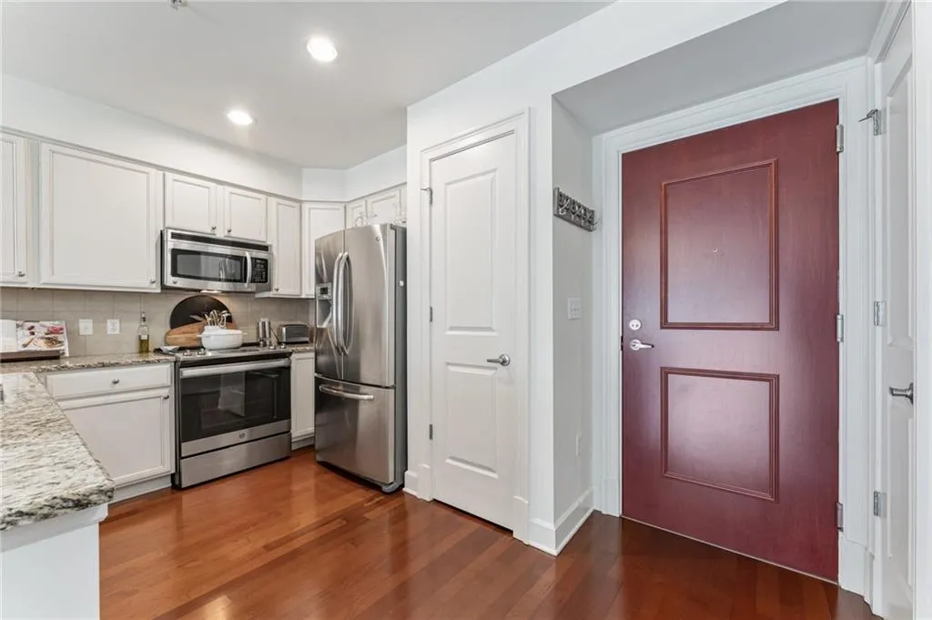 Custom finished white kitchen cabinets with stainless appliances. Food bar with granite countertop perfect for entertaining.