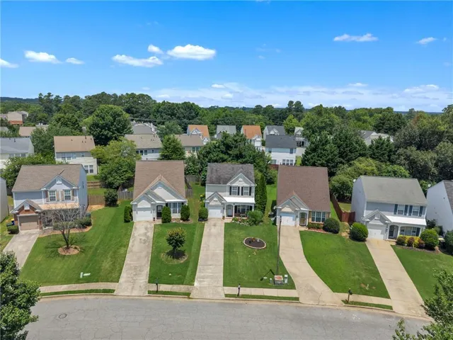 Residential neighborhood featuring multiple two-story homes with gabled roofs, concrete driveways, and landscaped front yards