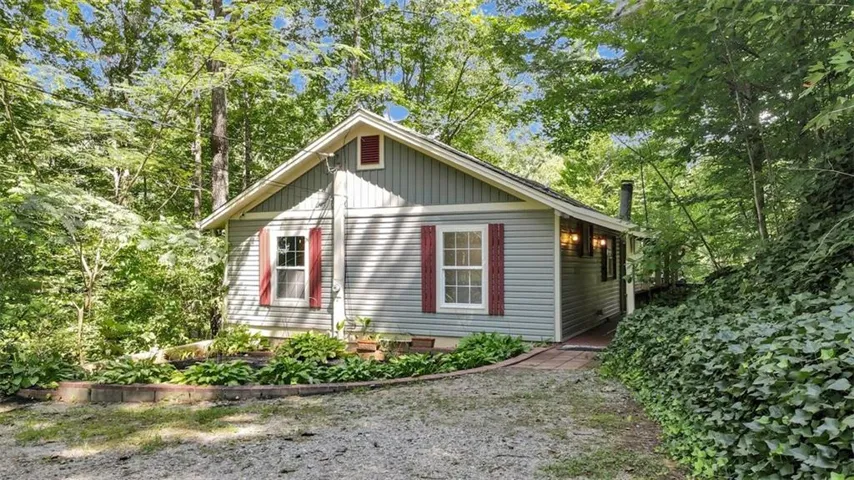 Light blue vinyl siding exterior with red window shutters