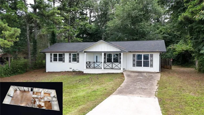 White exterior with dark roof and shutters, featuring a covered front porch with decorative railing and a concrete driveway