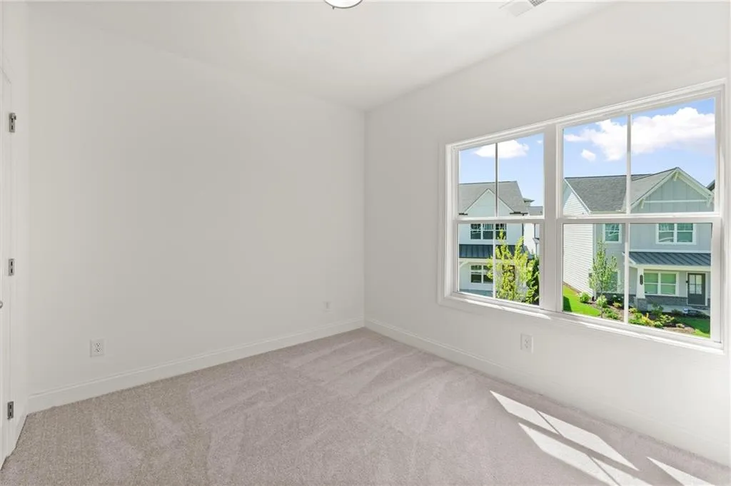 Carpeted spare room featuring baseboards