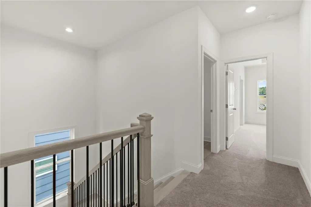 Hall with an upstairs landing, carpet, recessed lighting, and baseboards