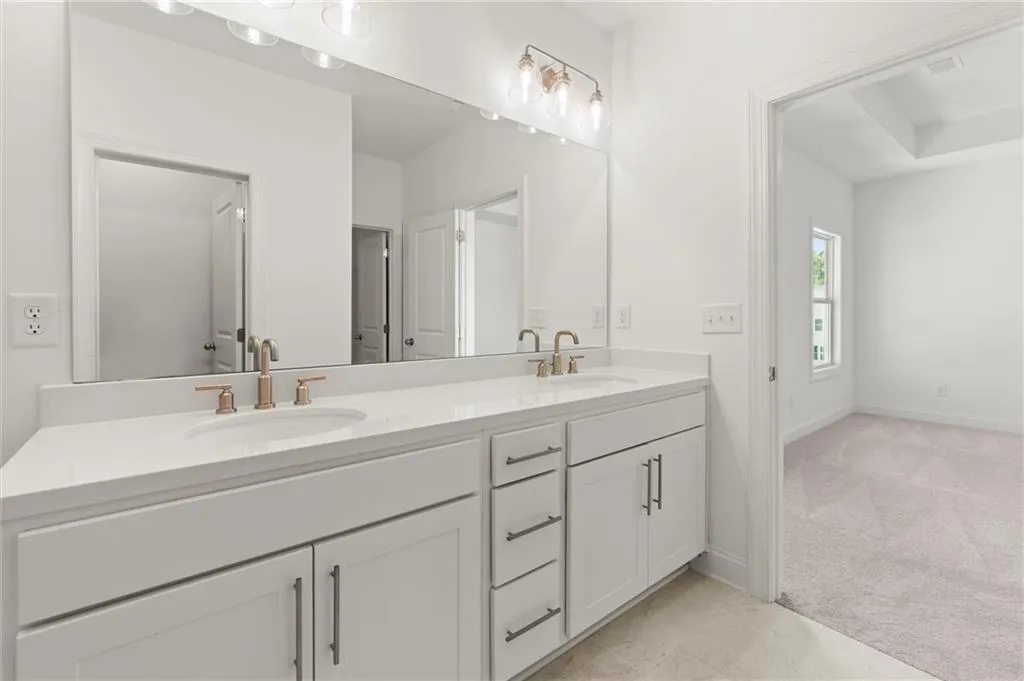 Bathroom featuring double vanity and baseboards