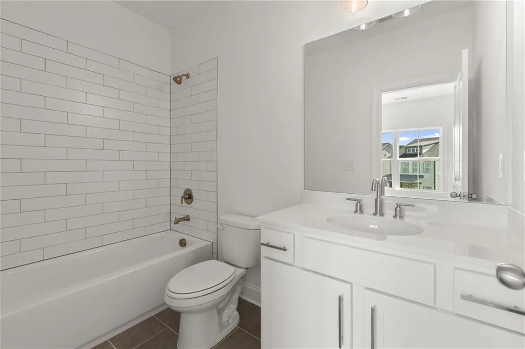 Full bath with toilet, vanity,  shower combination, and tile patterned flooring