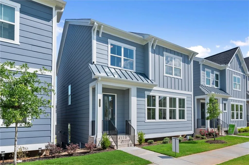 View of front of home featuring a standing seam roof, board and batten siding, a front lawn, and metal roof