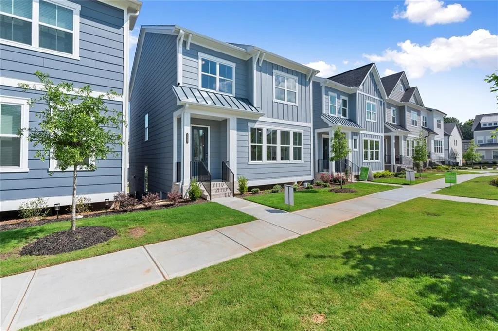 Single-family property featuring a residential view, a front lawn, a standing seam roof, and board and batten siding