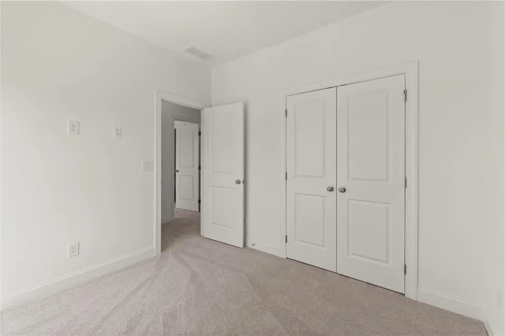 Unfurnished bedroom featuring carpet floors, baseboards, and a closet