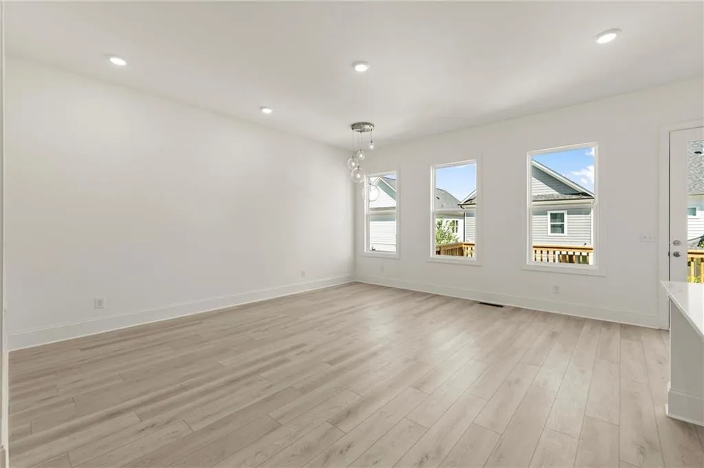 Spare room featuring light wood-type flooring, baseboards, and recessed lighting