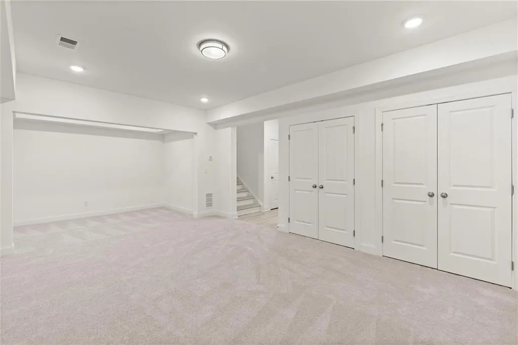 Finished below grade area with carpet, baseboards, stairway, and recessed lighting