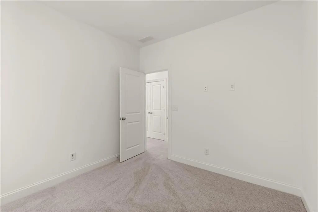 Unfurnished room with light colored carpet and baseboards