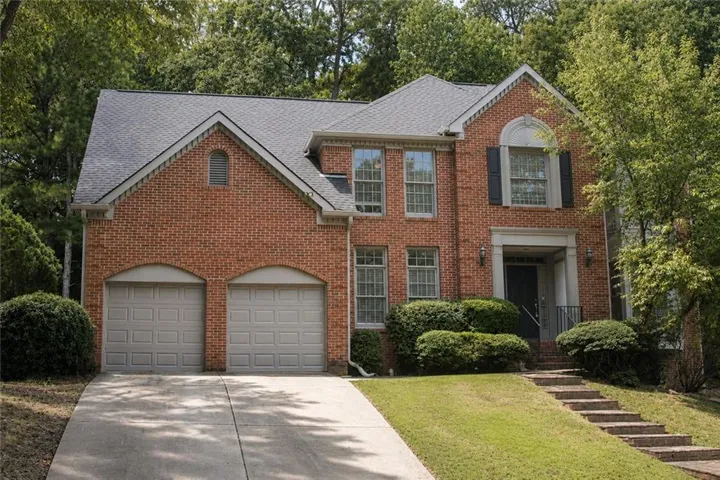 Brick exterior with architectural shingles and two-car garage