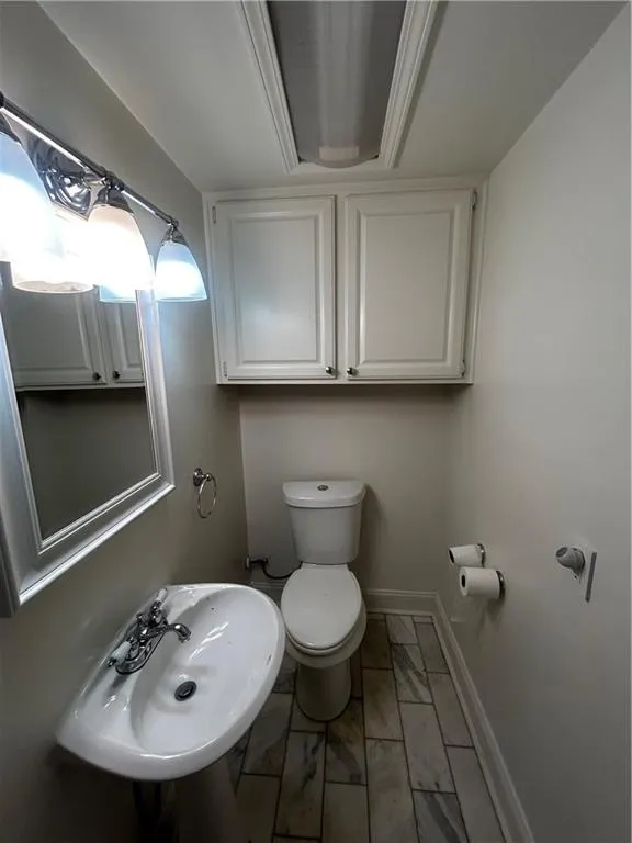 Half bath featuring toilet and baseboards
