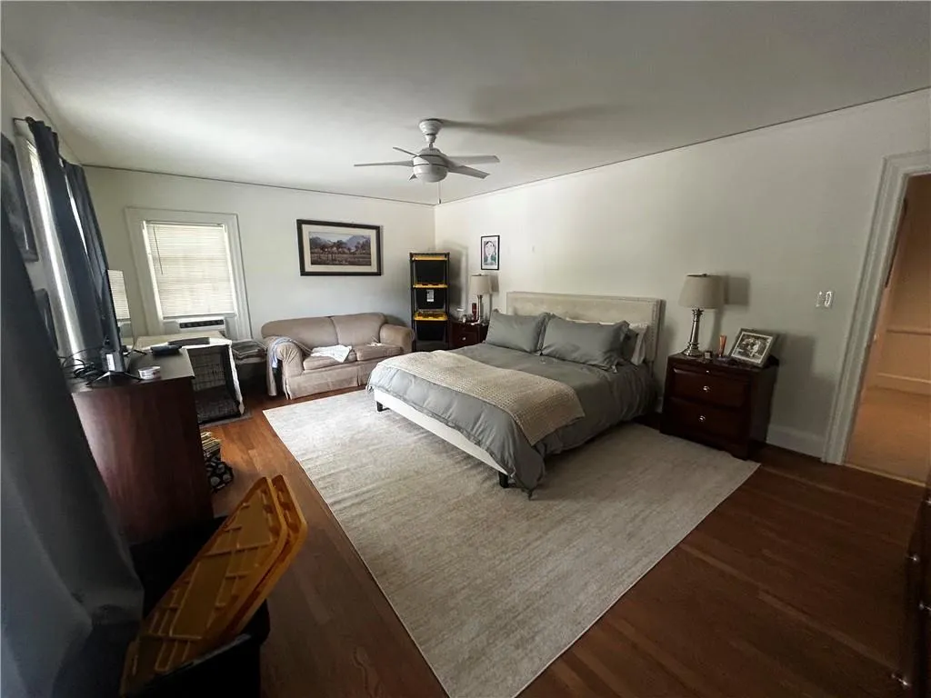 Bedroom with dark wood-type flooring and ceiling fan