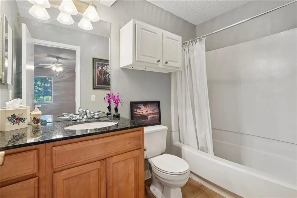Ensuite bathroom featuring shower / bath combo and raised vanity