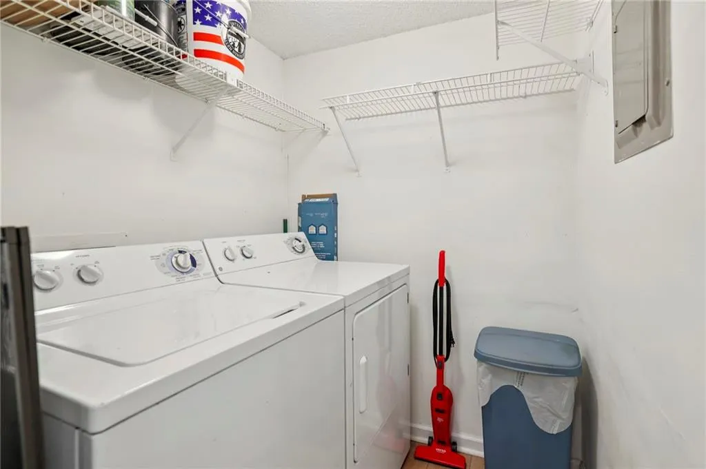 Laundry room/pantry with a textured ceiling, independent washer and dryer, and electric panel