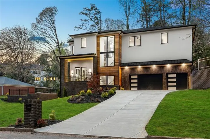 Contemporary exterior featuring white stucco, brick accents, and wood-finish siding