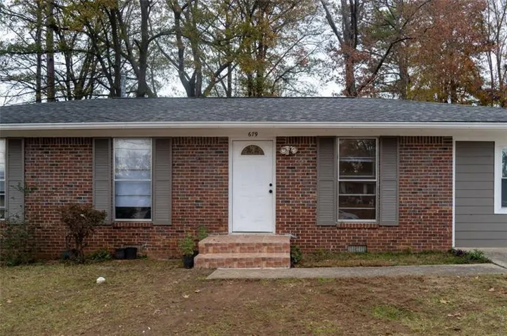 View of front of property with brick siding, entry steps, and crawl space