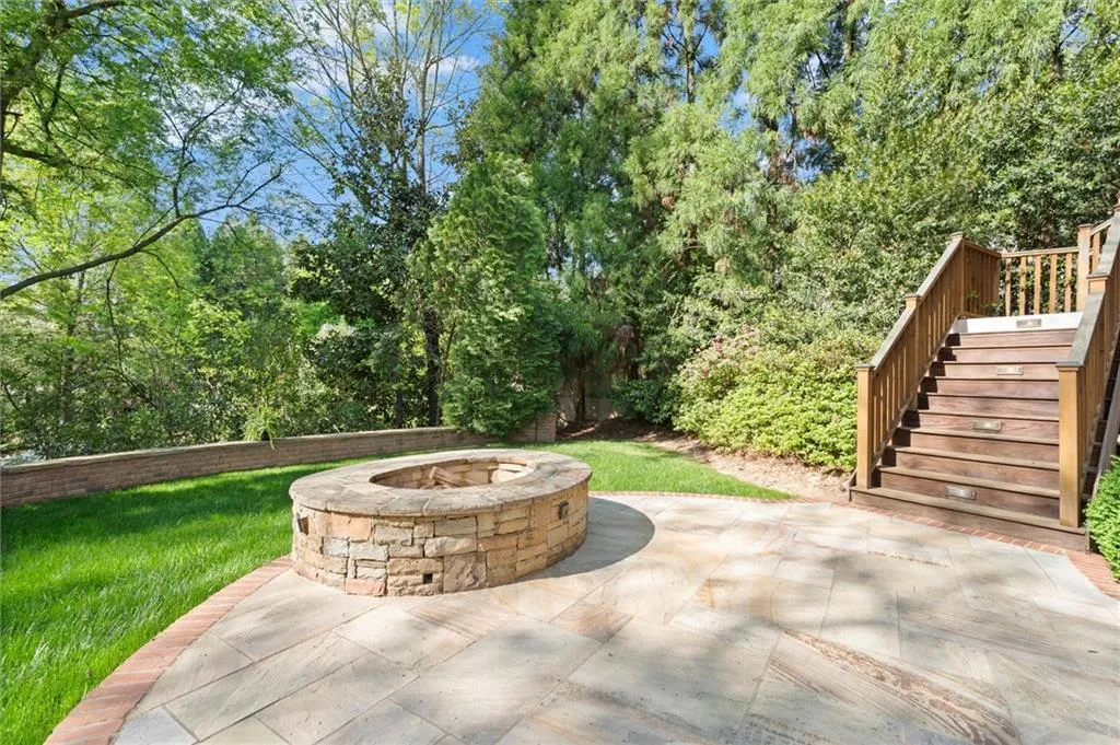 View of patio featuring an outdoor fire pit and view of scattered trees