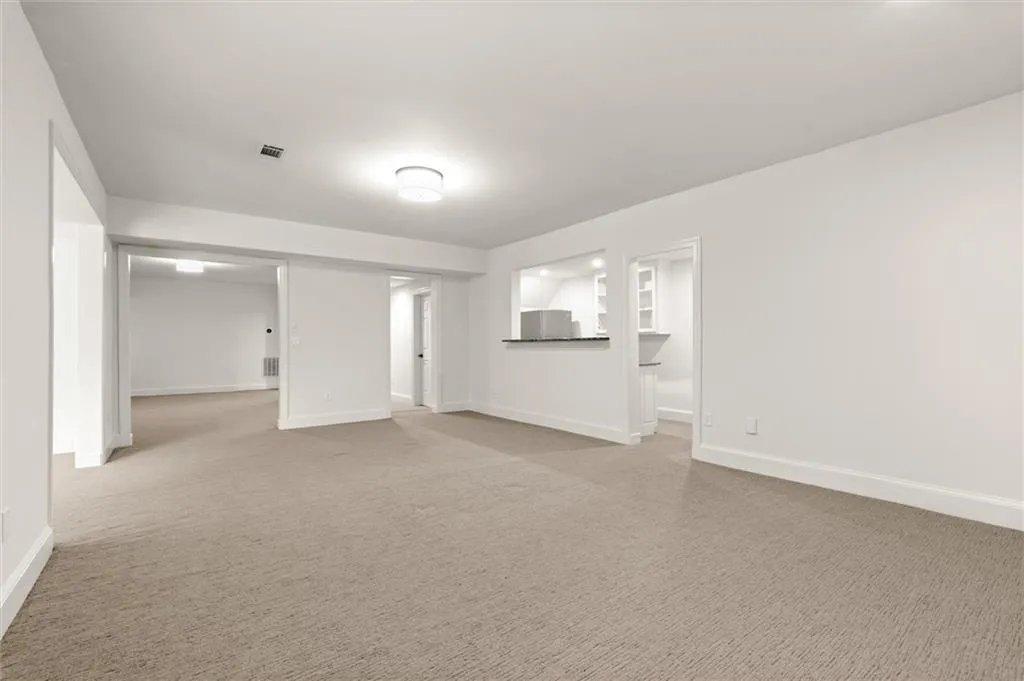 Unfurnished living room featuring light colored carpet and baseboards