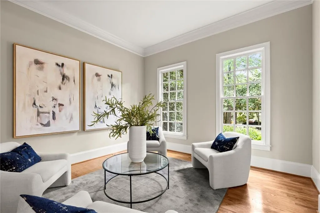 Living area with crown molding and wood finished floors