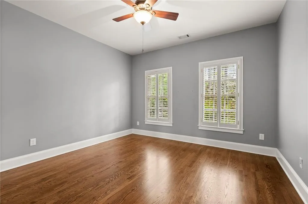 Empty room with dark wood-style floors and ceiling fan