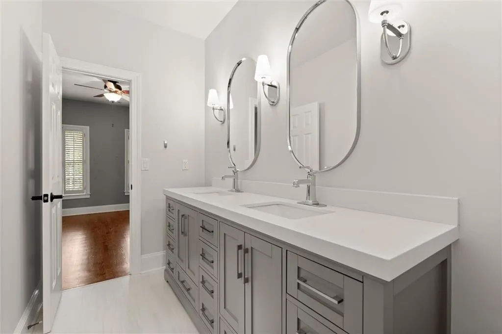 Full bath featuring double vanity and a ceiling fan