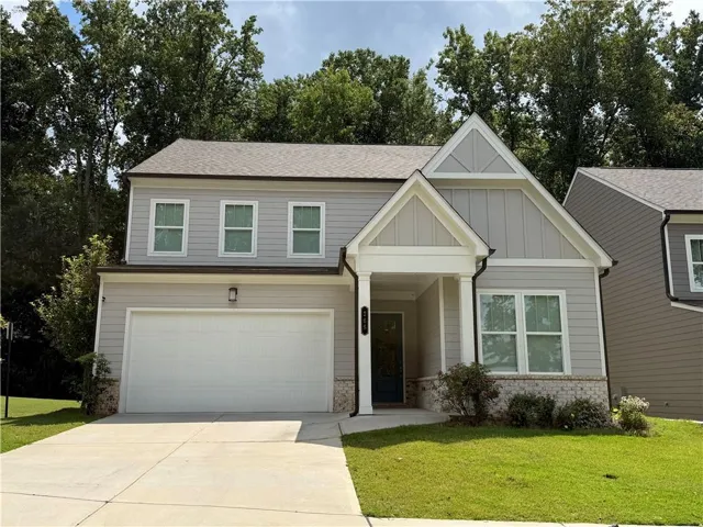 Light gray siding exterior with a stone veneer accent, white trim, and a two-car garage