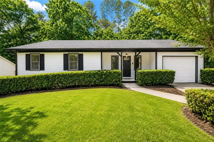 Single-story residence featuring a white siding exterior with contrasting black trim
