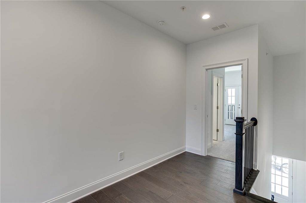 The upstairs hallway has hardwood floors and separates the 2 upstairs bedrooms.