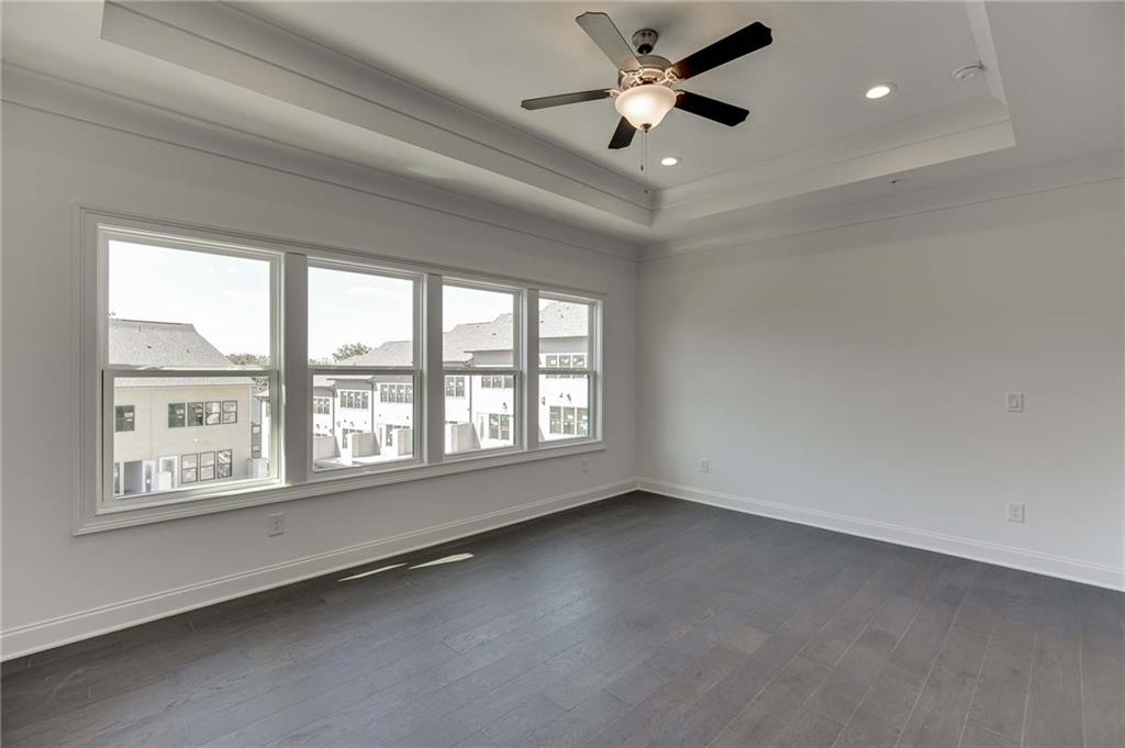 The primary suite offers hardwood floors, trey ceiling and additional can lighting.