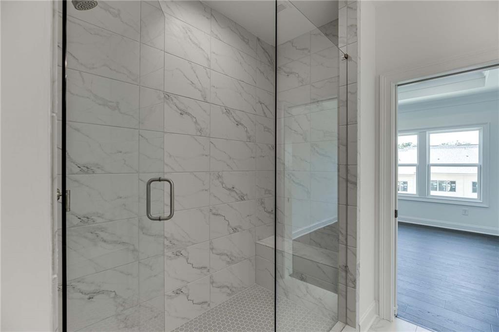 Enjoy the spa-like shower in the primary batah with tiled walls and frameless door.