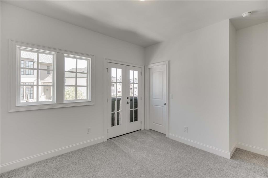 The secondary upstairs bedroom has french doors opening which adds more natural light to this home.