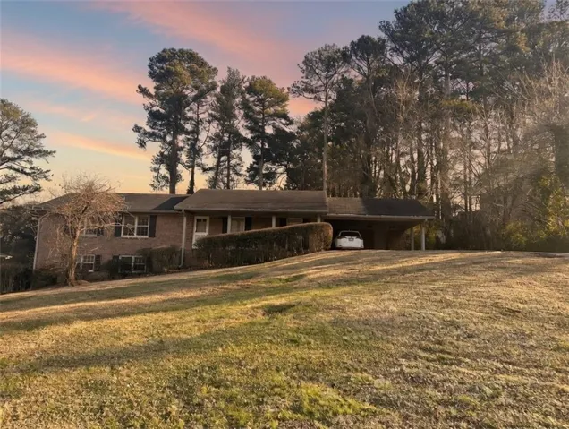 View of front of house featuring a front lawn and an attached carport