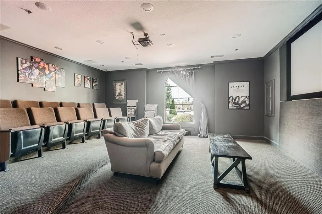 Home theater room with carpet flooring, a textured ceiling, and ornamental molding