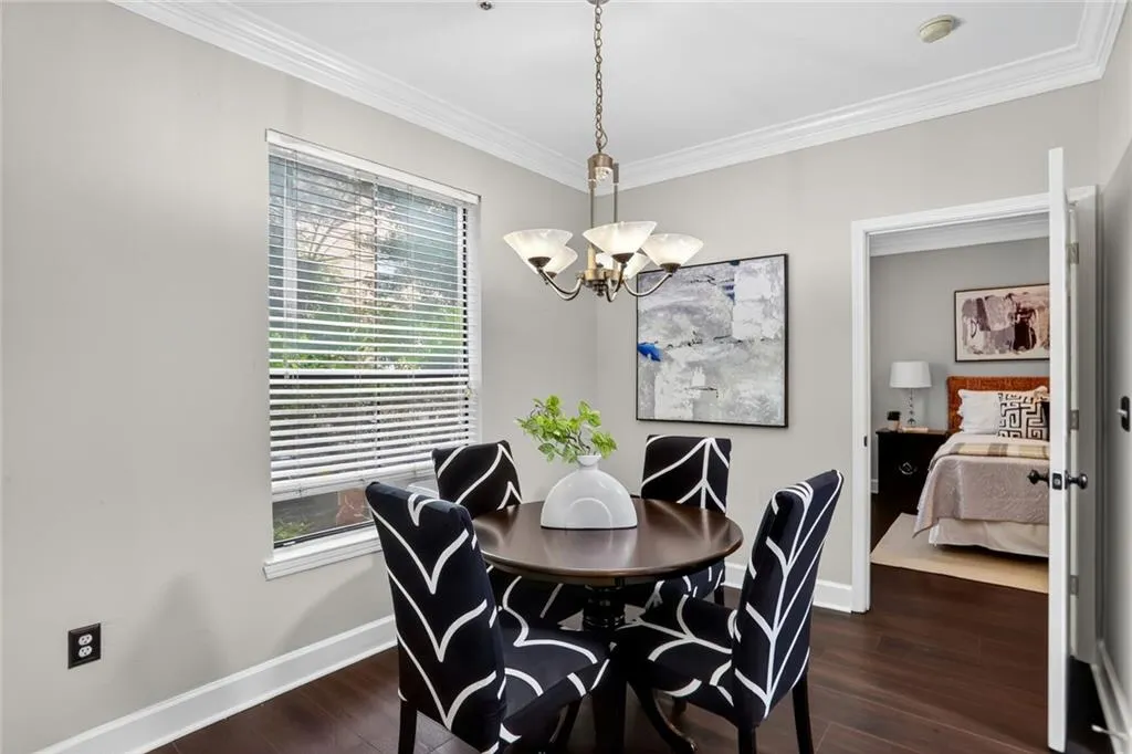 Dining room with a chandelier, ornamental molding, and dark wood-style flooring