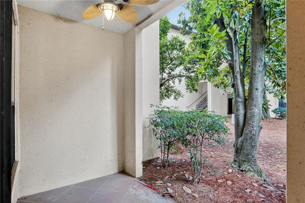 Entrance to property featuring ceiling fan and stucco siding