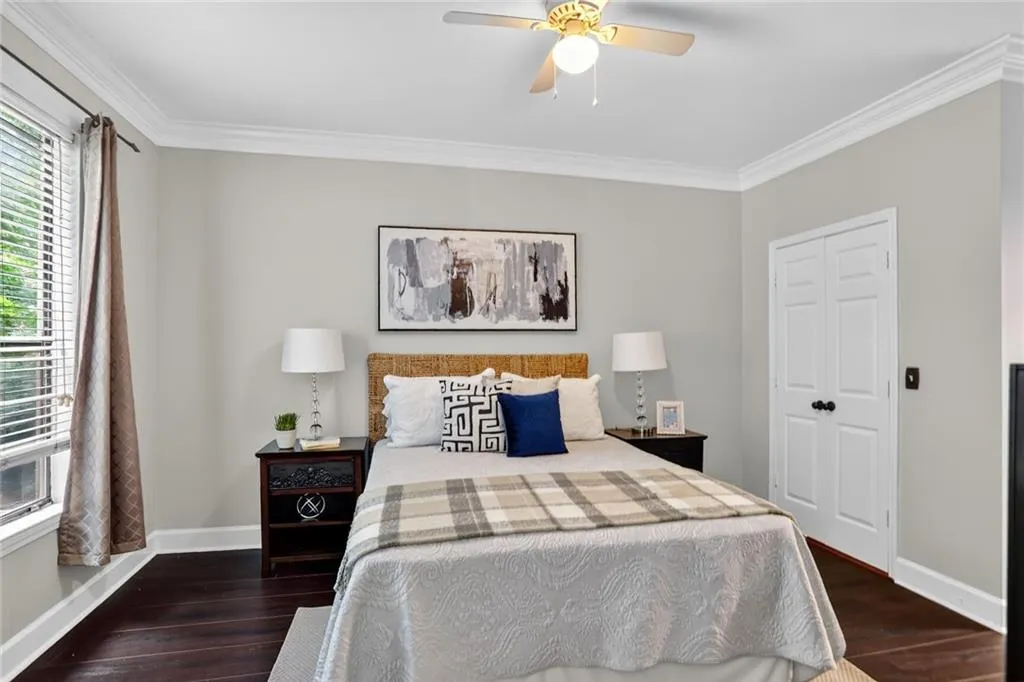 Bedroom featuring crown molding, wood finished floors, a ceiling fan, and a closet