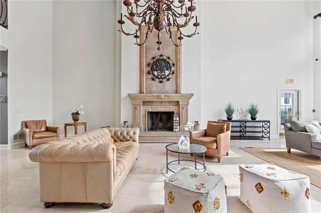 Living area with a high ceiling, a chandelier, and a premium fireplace
