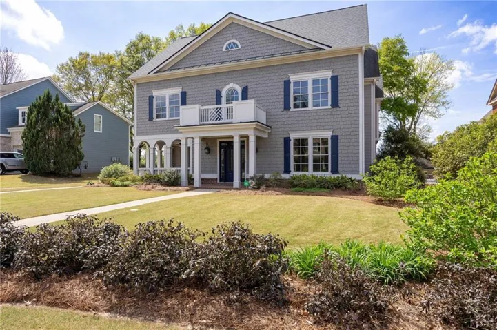 Georgian-style home featuring a porch and a front lawn