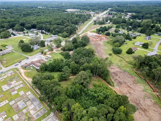 Aerial view of property and surrounding area with a heavily wooded area