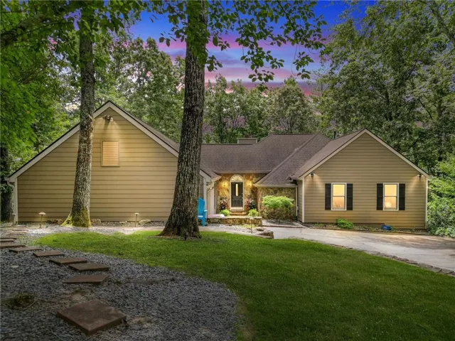Ranch-style residence featuring tan siding and natural stone accents