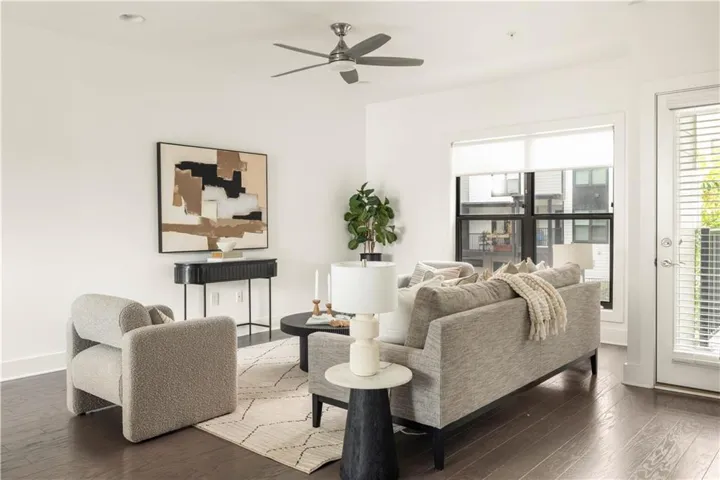 Recessed lighting, wood-finish flooring, ceiling fan, large window with roller shades, and a glass-paneled door