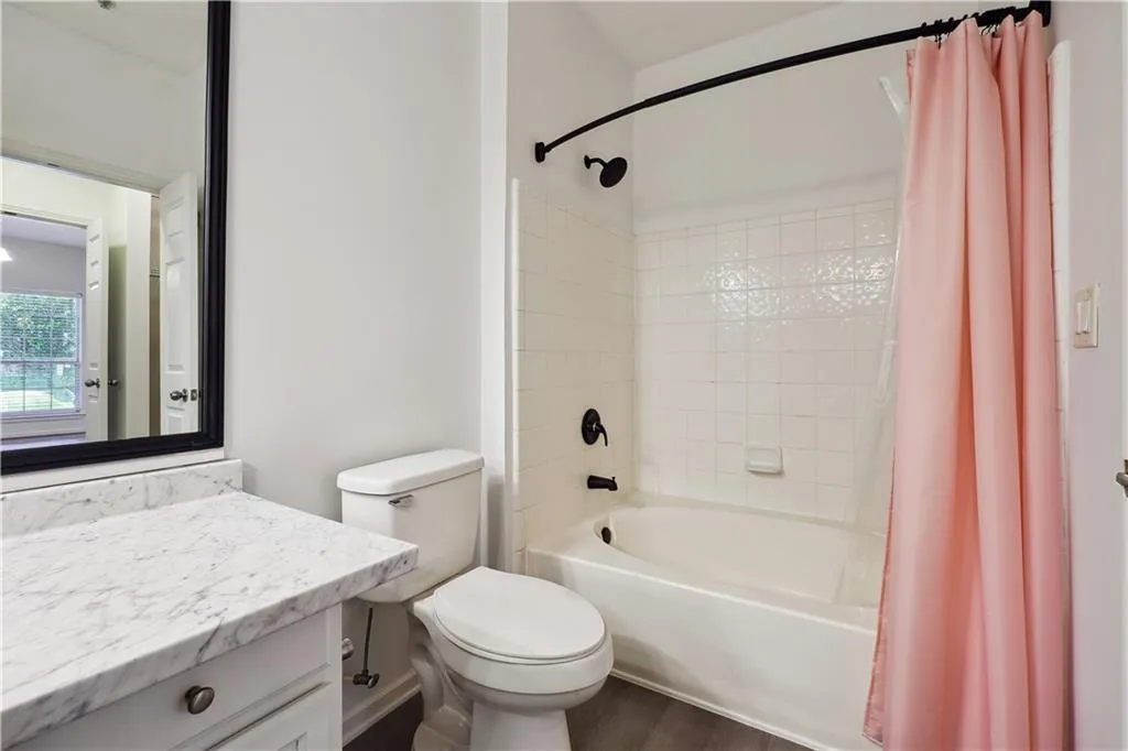 Full bathroom with hardwood / wood-style flooring, vanity, toilet, and shower / tub combo
