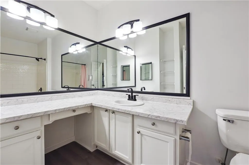 Bathroom featuring hardwood / wood-style flooring, vanity, toilet, and walk in shower