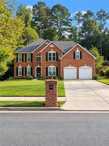 Brick exterior with an arched entryway, gabled rooflines, and a two-car garage
