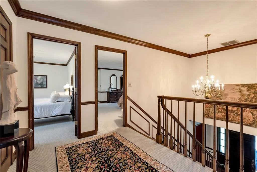 Hall featuring ornamental molding, carpet floors, and a chandelier