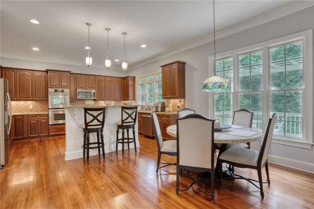 Dining space with light wood-type flooring and crown molding