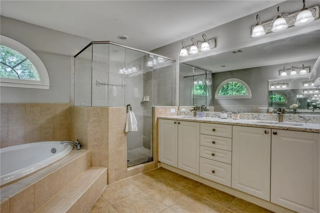 Bathroom featuring vanity, plenty of natural light, and separate shower and tub