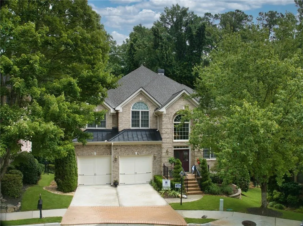 View of front of property with a large two car garage and a front lawn cul-de-sac
